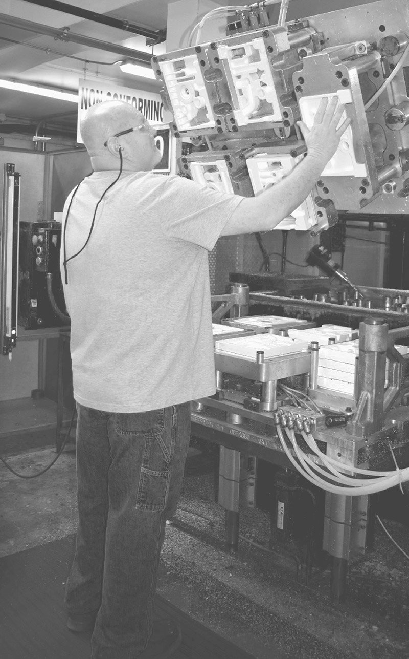 Operator handling an aluminum mold at BRP Spruce Pine in an industrial production environment