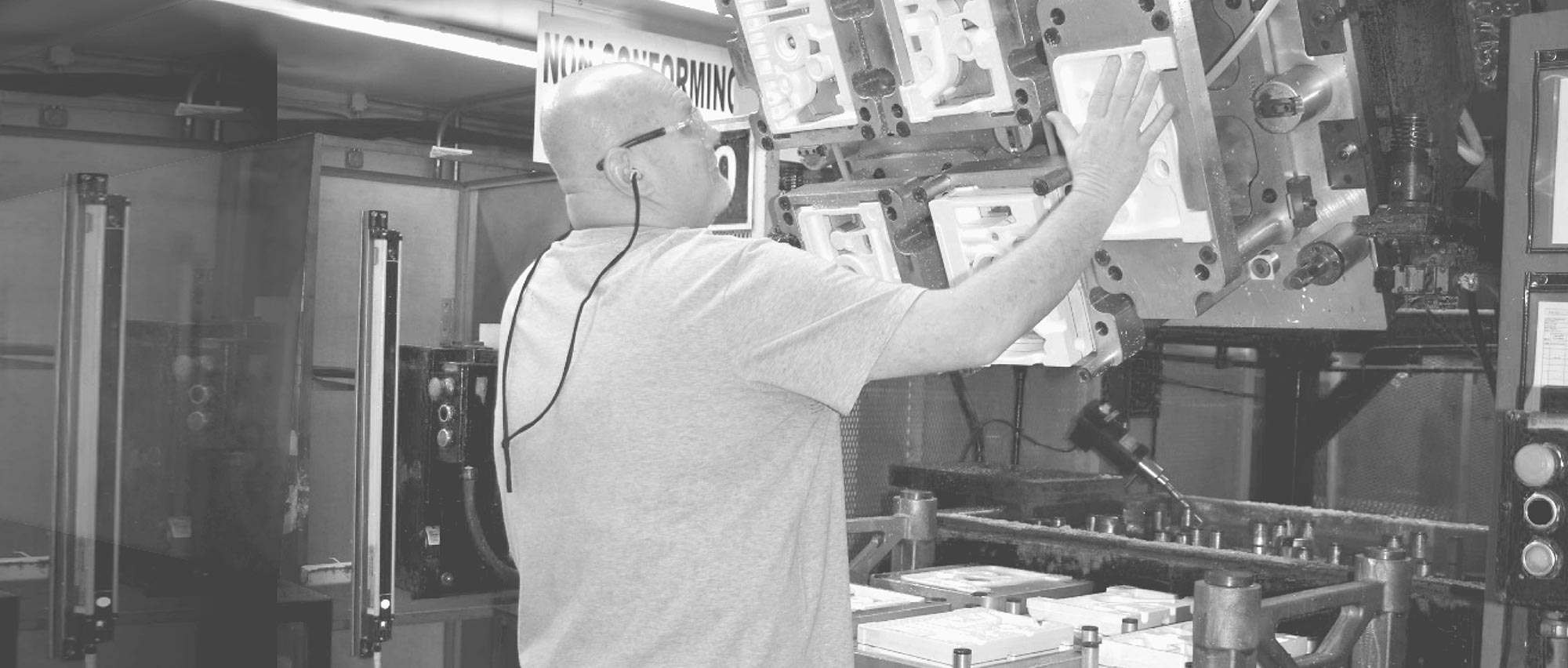 Operator handling an aluminum mold at BRP Spruce Pine in an industrial production environment