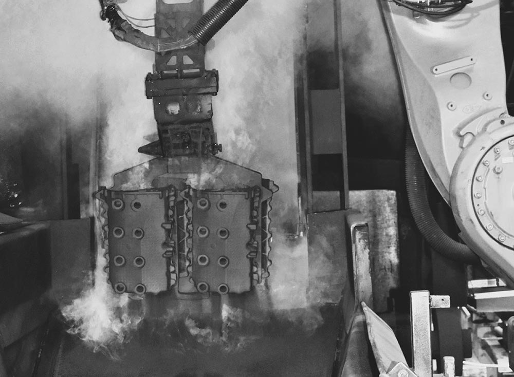 Industrial robot handling an aluminum part in a foundry environment at the BRP Spruce Pine plant